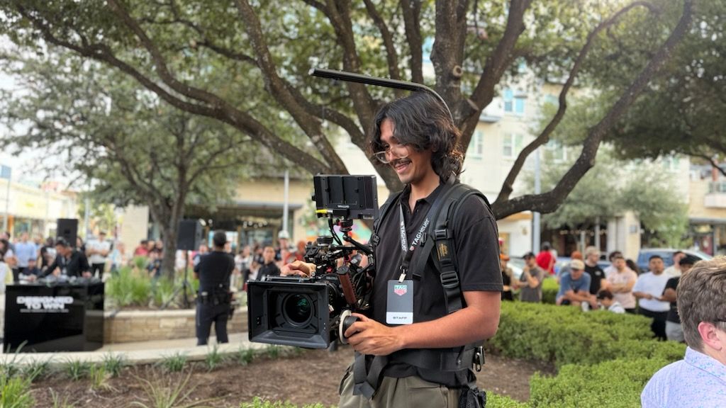 An expert Austin event videographer from the Beverly Boy Productions team operates a professional cinema camera rig at the TAG Heuer grand opening event.
